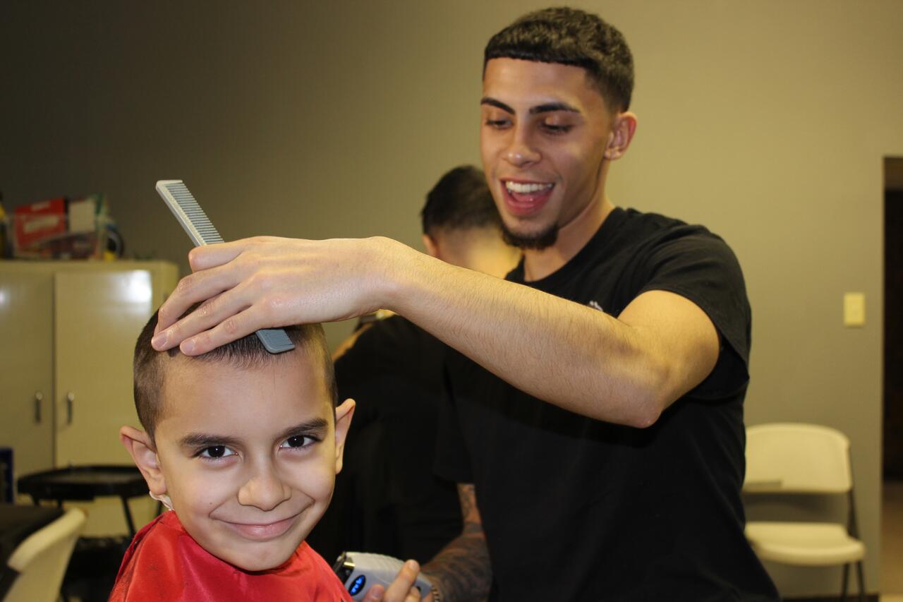 Albion barber cuts hair, supports children in community